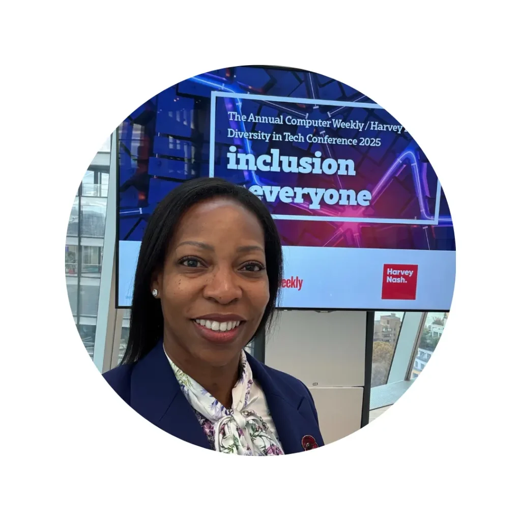 Beverly Clarke MBE smiling in front of a presentation screen at the Annual Computer Weekly / Harvey Nash Diversity in Tech Conference 2025.